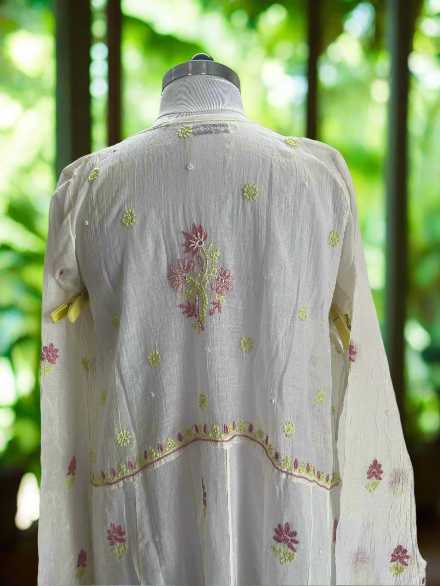 White embroidered blouse on a mannequin against a plain background