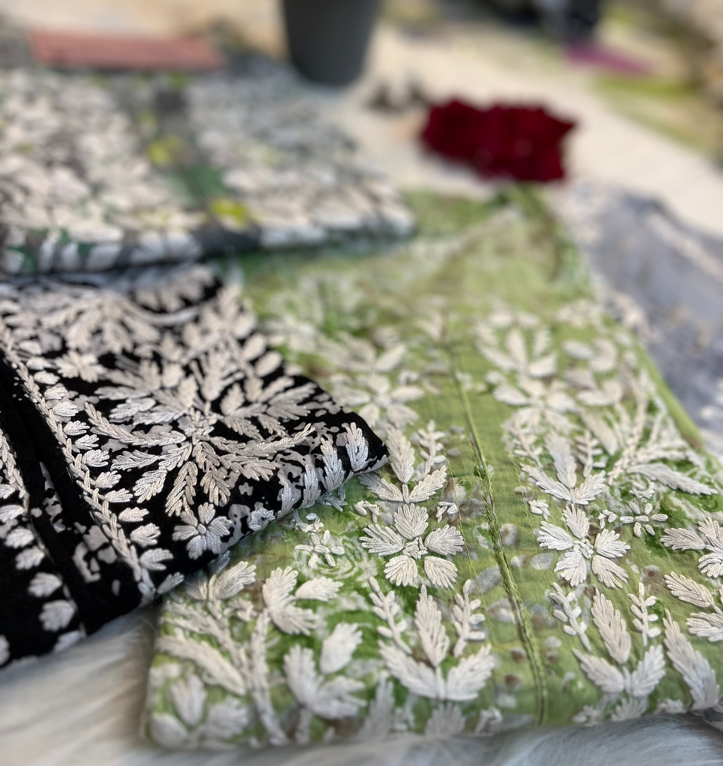 Decorative pillows with floral patterns on a table outdoors.