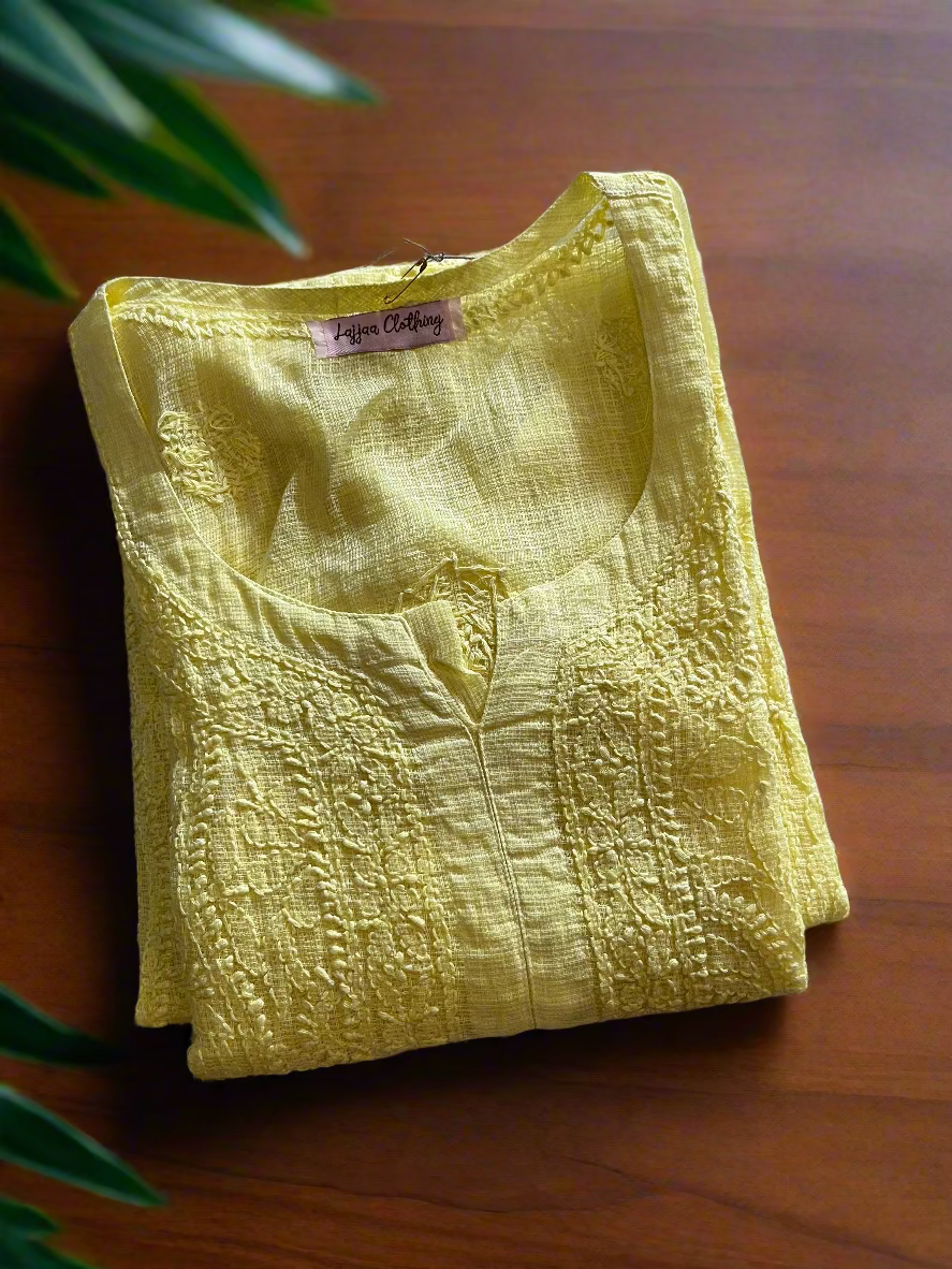 Folded yellow garment with a brand tag on a floral-patterned surface