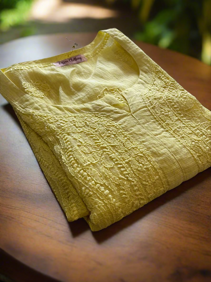 Folded yellow garment on a floral-patterned surface