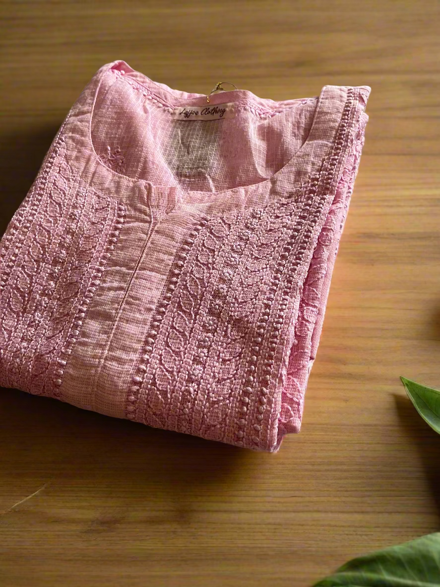Folded pink garment on a floral-patterned surface