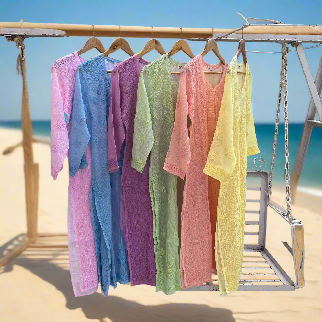 Colorful dresses hanging on a rack with a beach background