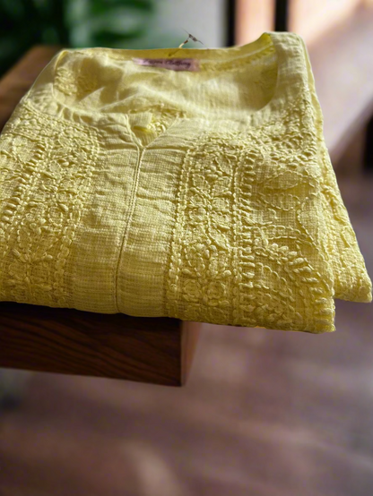 Yellow textured fabric on a floral-patterned surface