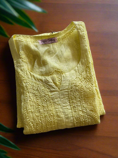 Folded yellow garment with a brand tag on a floral-patterned surface