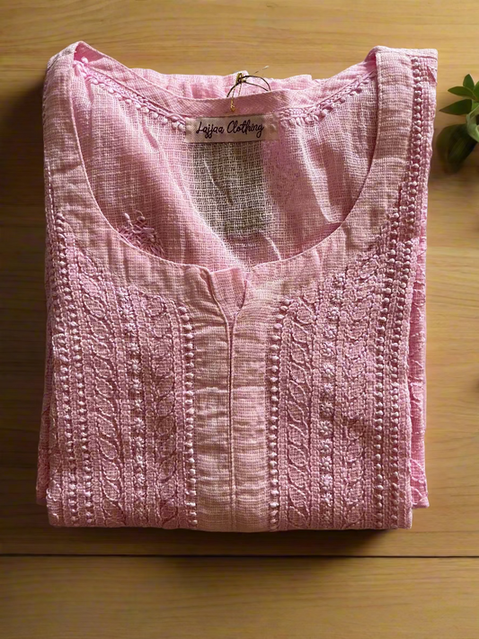 Folded pink top with 'Lulus Clothing' label on a floral-patterned surface