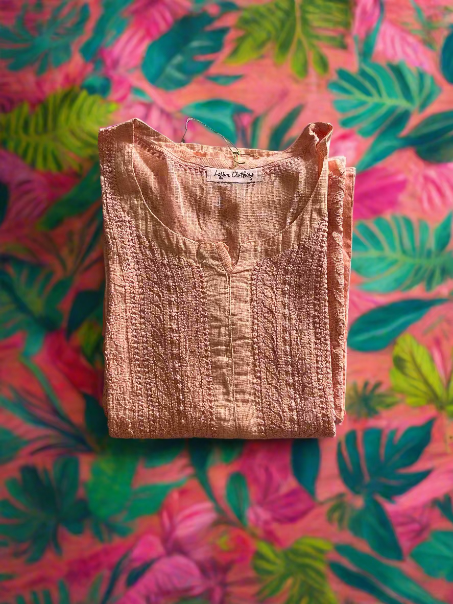 Folded pink garment on a floral-patterned surface