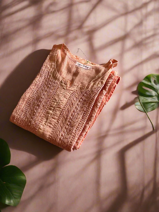 Folded pink textured fabric on a floral-patterned surface